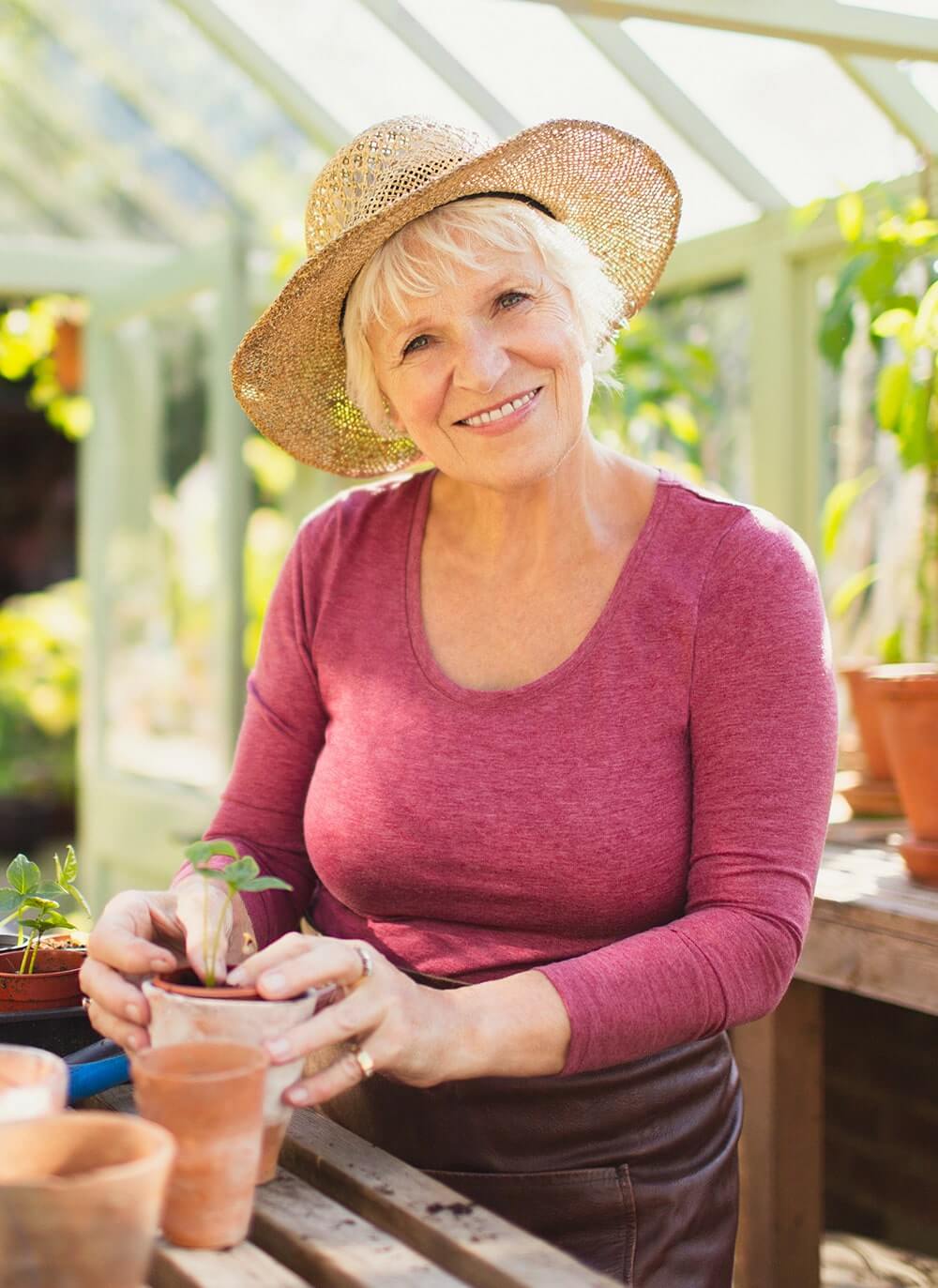 Smiling senior woman potting a plant