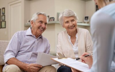 Older couple smiling as they talk to a financial planner about their estate