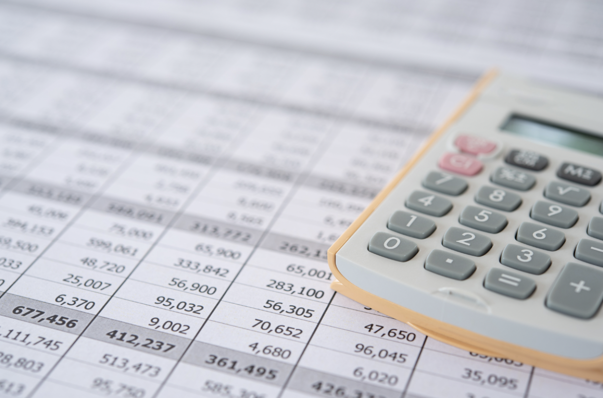 Calculator and financial records spread out on a table, illustrating the process of rebuilding finances and organizing assets after divorce.